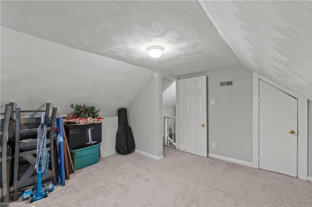 additional living space featuring visible vents, baseboards, lofted ceiling, and carpet floors