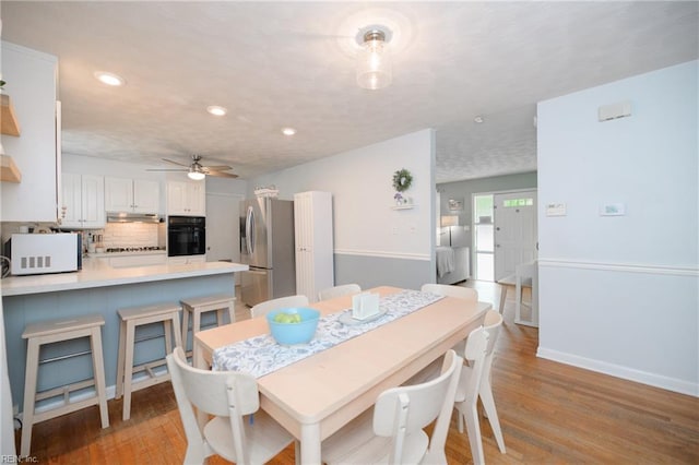 dining space with ceiling fan, baseboards, light wood finished floors, and recessed lighting