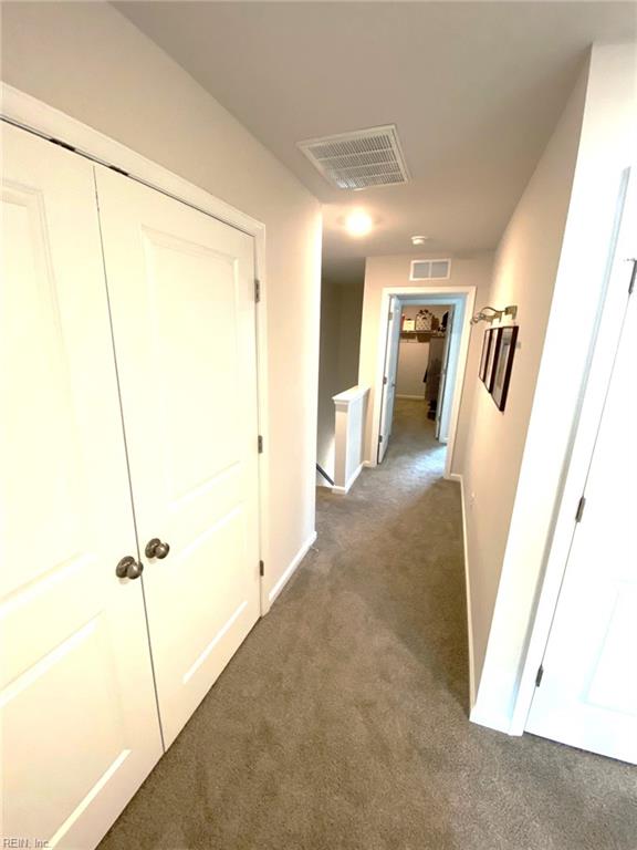 1547 Stanford Ln, Newport News, VA 23608 - corridor with visible vents, carpet floors, and an upstairs landing