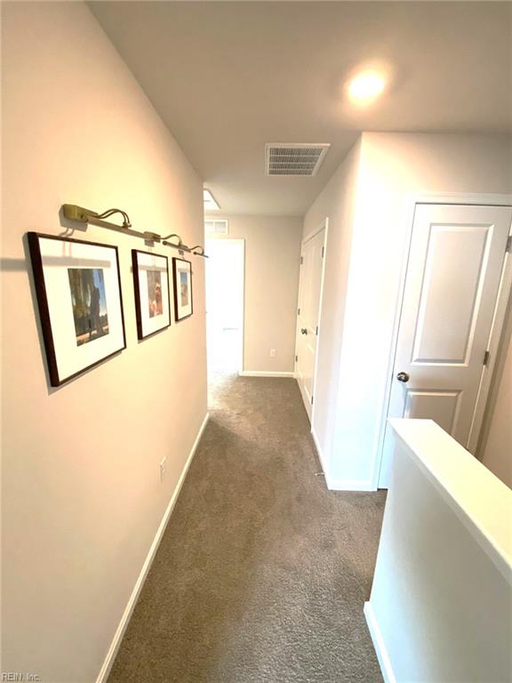1547 Stanford Ln, Newport News, VA 23608 - hallway with visible vents, dark colored carpet, and baseboards
