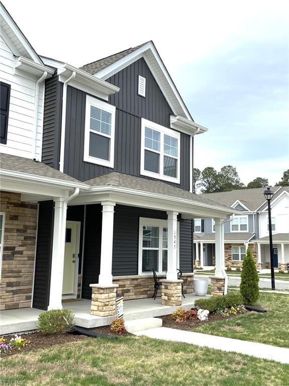 1547 Stanford Ln, Newport News, VA 23608 - craftsman-style house featuring board and batten siding, stone siding, a front yard, and covered porch
