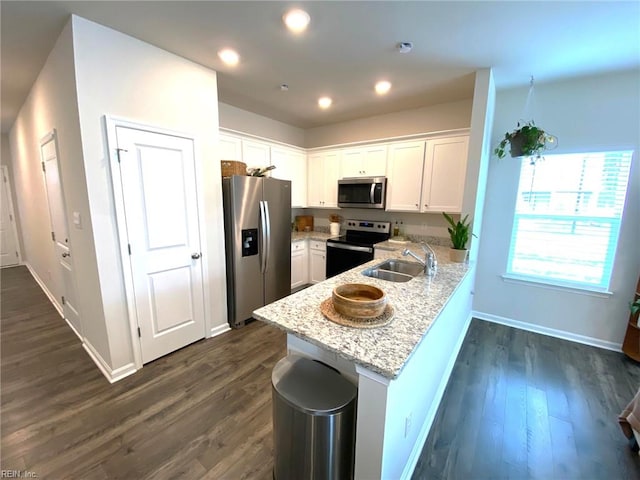 1547 Stanford Ln, Newport News, VA 23608 - kitchen with a peninsula, white cabinetry, stainless steel appliances, and a sink