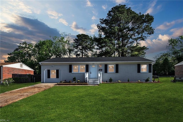 ranch-style house with fence, a front lawn, and driveway