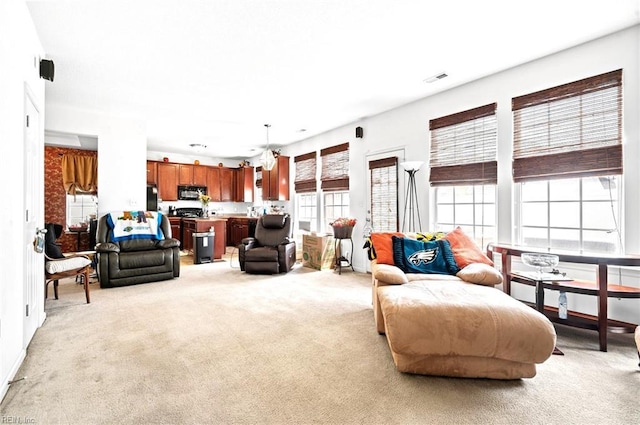living room featuring light colored carpet and ceiling fan