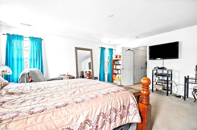 carpeted bedroom with a textured ceiling and visible vents