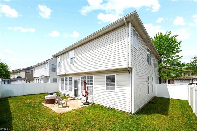 rear view of house with a yard, a fenced backyard, and a patio
