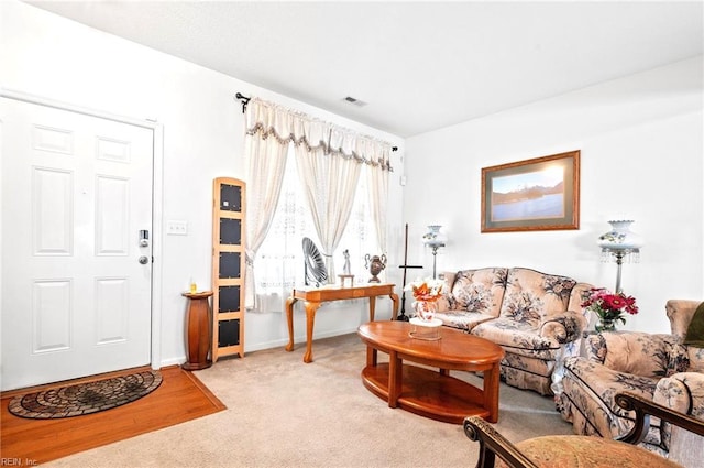 living room featuring light colored carpet, baseboards, and visible vents