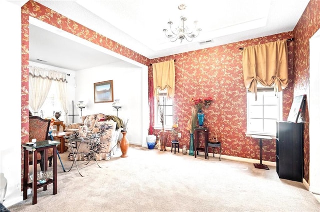 living area with carpet floors, a notable chandelier, visible vents, and plenty of natural light