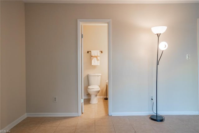 bathroom featuring toilet, tile patterned floors, and baseboards