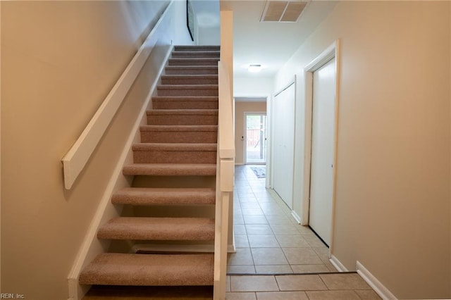 stairway featuring visible vents and tile patterned flooring