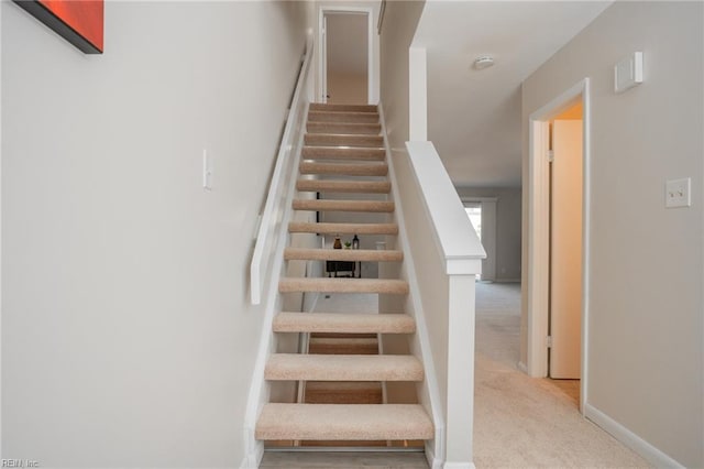 stairway featuring carpet floors and baseboards