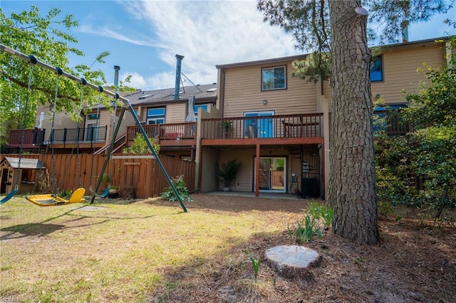 back of house featuring a wooden deck and a yard