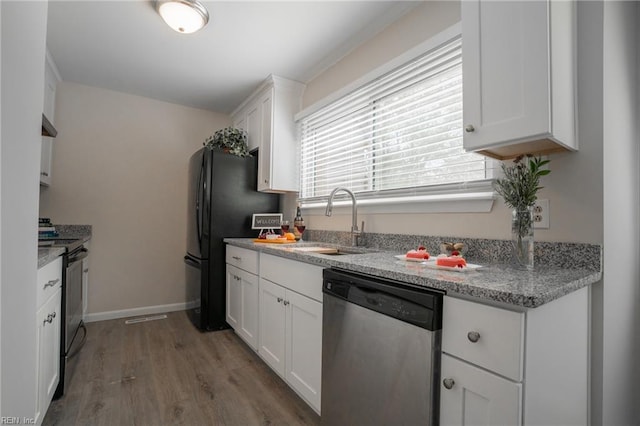 kitchen featuring wood finished floors, stainless steel dishwasher, a sink, gas stove, and white cabinetry