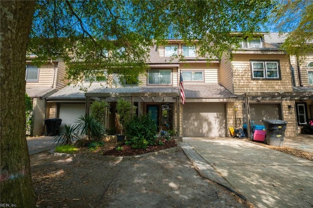 view of property with an attached garage, driveway, and a porch