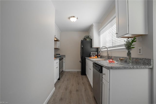 kitchen with light wood finished floors, a sink, baseboards, appliances with stainless steel finishes, and white cabinetry