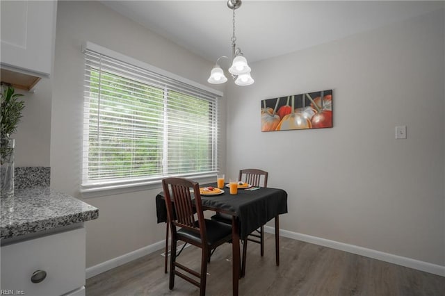 dining area featuring a wealth of natural light, baseboards, light wood-style floors, and a chandelier