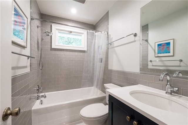bathroom with a wainscoted wall, shower / bath combo with shower curtain, toilet, tile walls, and vanity