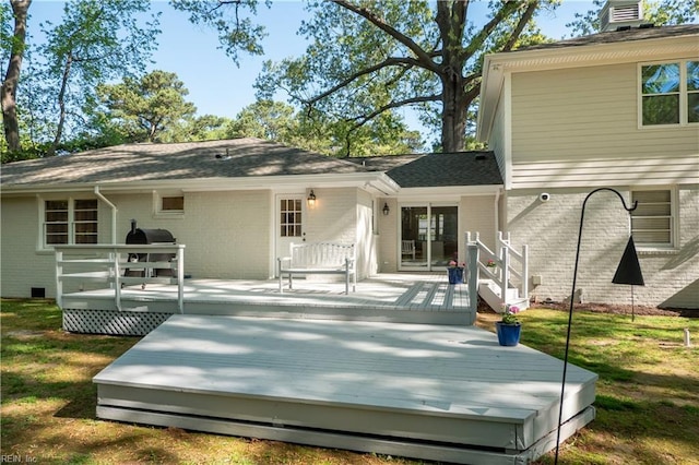 back of house with a wooden deck, a chimney, and brick siding