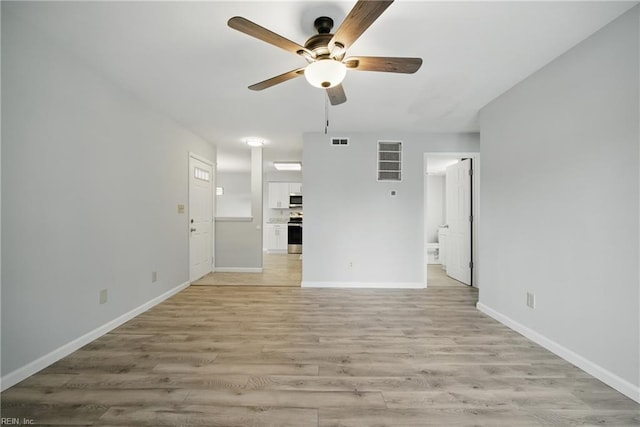 unfurnished living room with light wood finished floors, a ceiling fan, visible vents, and baseboards