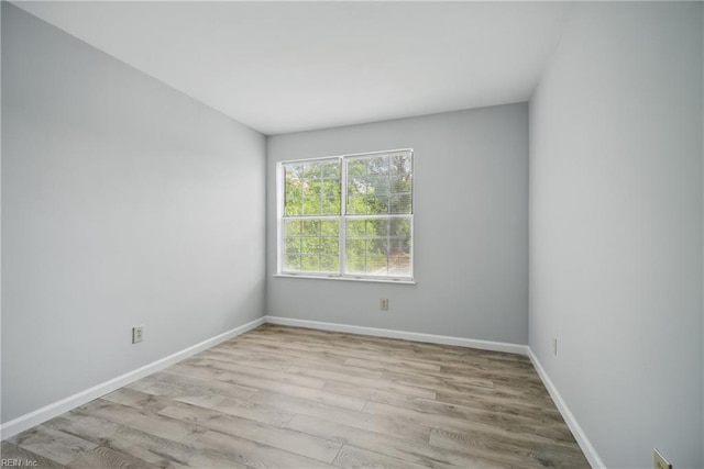 spare room featuring wood finished floors and baseboards