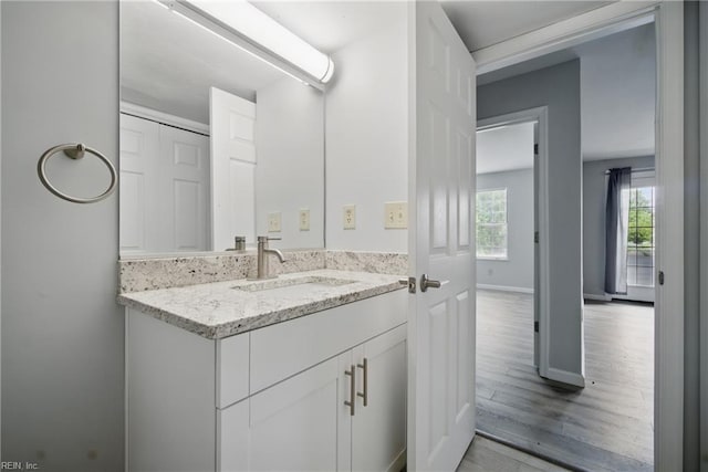bathroom featuring baseboards, wood finished floors, and vanity