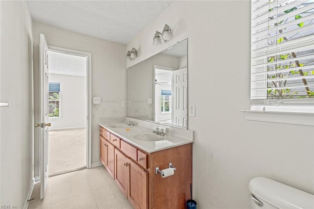 3605 Shell Rd, Hampton, VA 23661 - bathroom with double vanity, a textured ceiling, toilet, and a sink