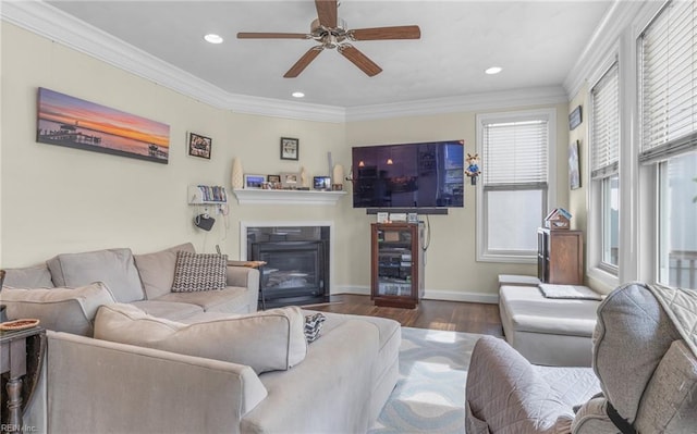living room featuring a fireplace with flush hearth, recessed lighting, wood finished floors, crown molding, and ceiling fan