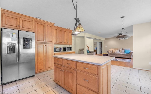 kitchen featuring light tile patterned flooring, pendant lighting, stainless steel appliances, and light countertops