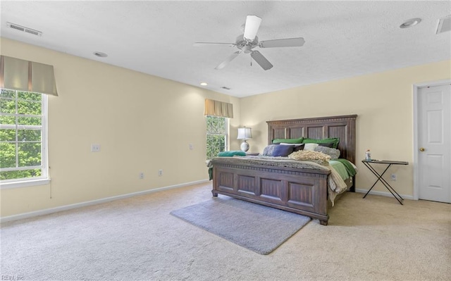 carpeted bedroom with ceiling fan, visible vents, and baseboards