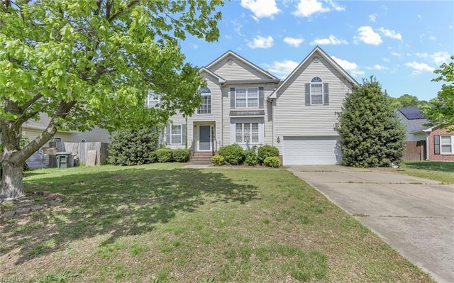 traditional home featuring a front yard, a garage, and concrete driveway