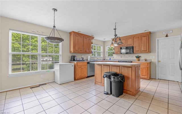 kitchen featuring stainless steel dishwasher, black microwave, light countertops, a center island, and refrigerator