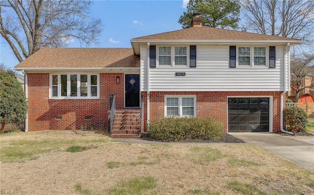 tri-level home featuring concrete driveway, an attached garage, brick siding, and a chimney