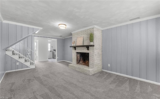 unfurnished living room featuring stairway, carpet floors, ornamental molding, and a brick fireplace