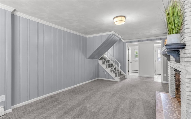 unfurnished living room with a baseboard heating unit, baseboards, crown molding, and stairs