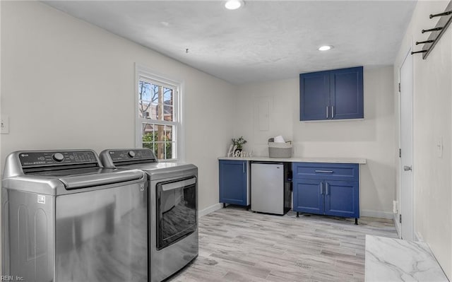 washroom with recessed lighting, light wood-type flooring, washing machine and clothes dryer, baseboards, and cabinet space