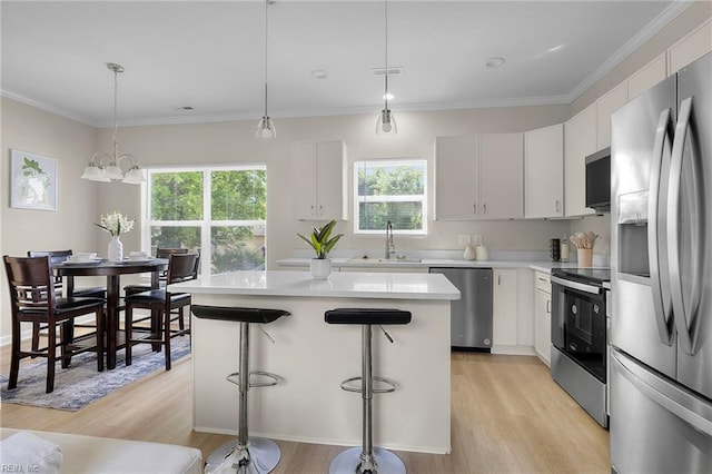 kitchen with a wealth of natural light, appliances with stainless steel finishes, a sink, and light wood-style flooring