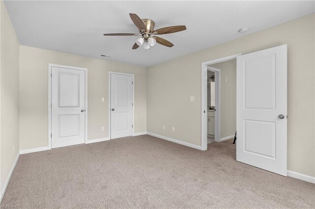 unfurnished bedroom featuring carpet floors, visible vents, a ceiling fan, and baseboards