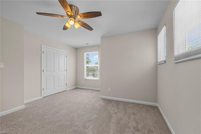 unfurnished bedroom featuring ceiling fan, carpet floors, a closet, and baseboards
