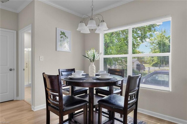 dining space with baseboards, a notable chandelier, crown molding, and light wood-type flooring