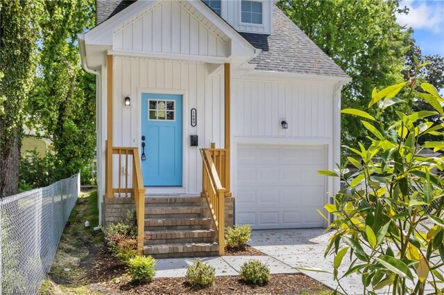 view of exterior entry with fence, a chimney, roof with shingles, and board and batten siding