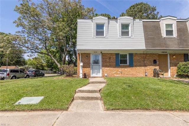 view of front of home featuring brick siding and a front lawn