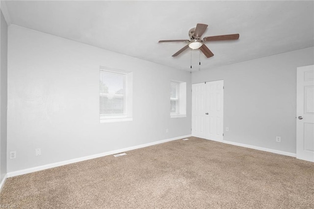 unfurnished room featuring baseboards, a ceiling fan, and carpet floors