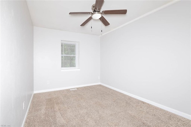 carpeted empty room with ceiling fan and baseboards