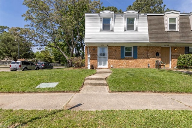 view of front of property with a front lawn and brick siding
