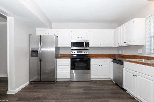 kitchen with dark countertops, dark wood-style flooring, and appliances with stainless steel finishes