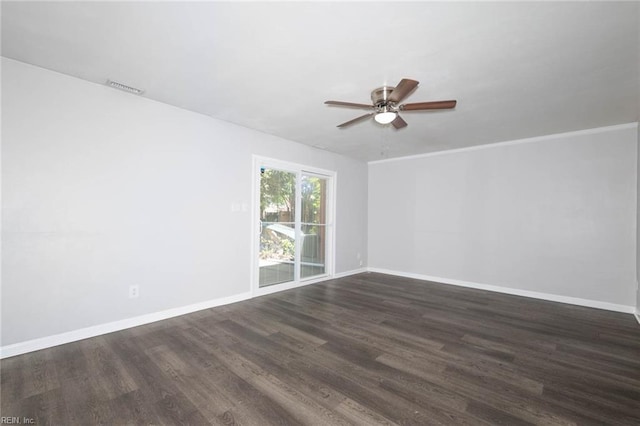 empty room with visible vents, a ceiling fan, dark wood finished floors, and baseboards