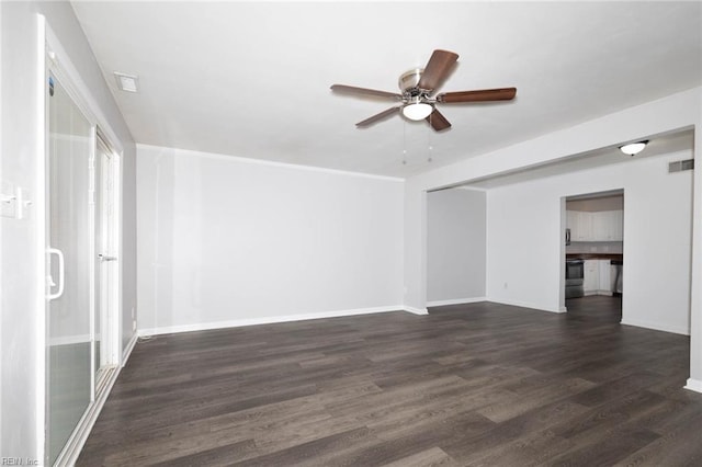 spare room featuring visible vents, a ceiling fan, dark wood finished floors, and baseboards