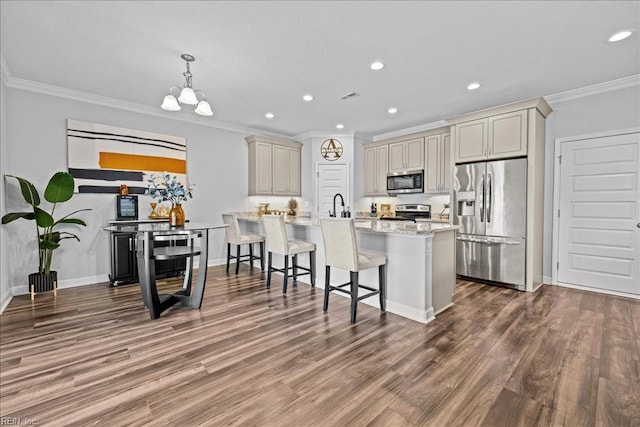 kitchen featuring ornamental molding, a kitchen bar, recessed lighting, light stone counters, and appliances with stainless steel finishes