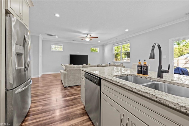 kitchen featuring a sink, ornamental molding, stainless steel appliances, recessed lighting, and dark wood-type flooring