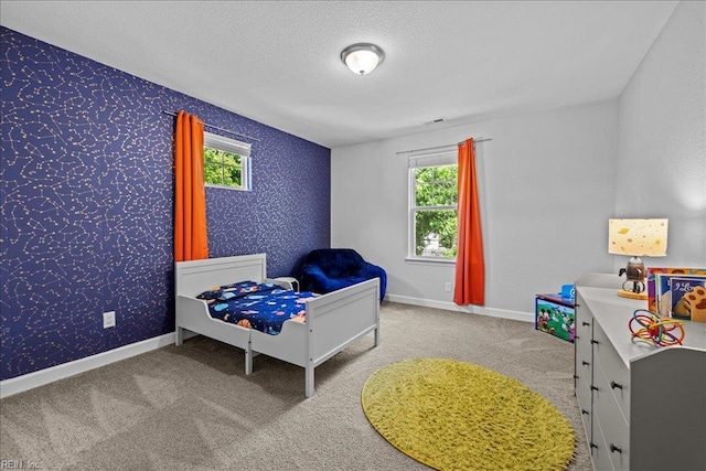 carpeted bedroom with baseboards, a textured ceiling, and wallpapered walls